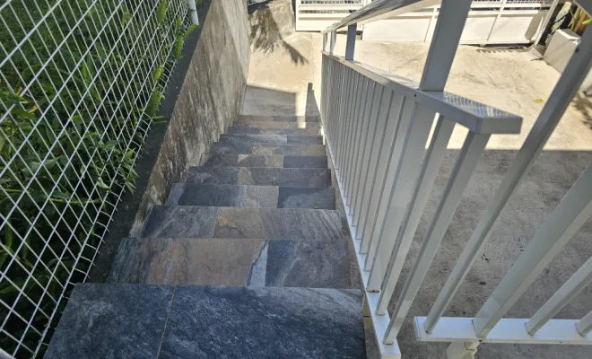 Réalisation d'un escalier en béton avec installation d'une main courante. Pose de carrelage antidérapant et dallage en contre bas pour accès au garage.  